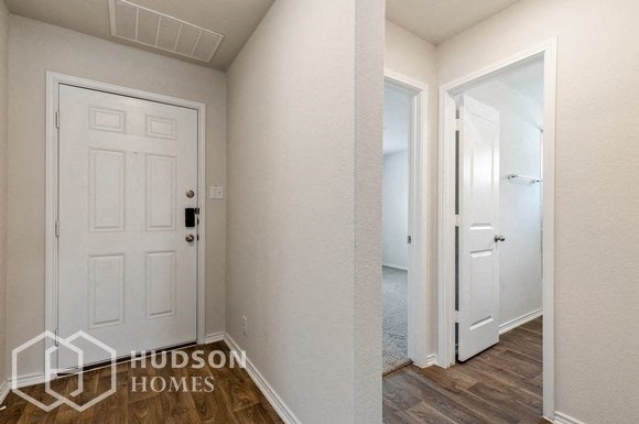 a bedroom with a white door and a hallway with a door to a closet