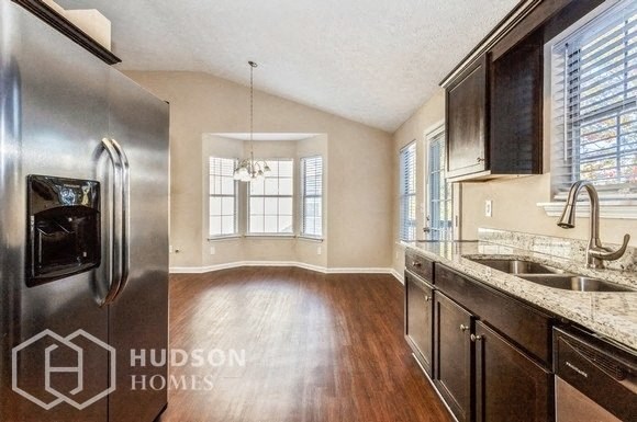 a kitchen with a stainless steel refrigerator and a sink