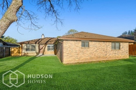 a brick house with a yard and a tree