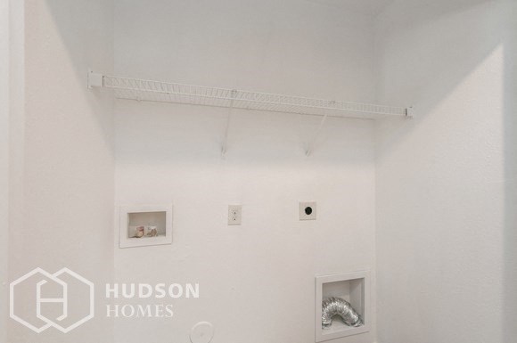 a room with white walls and two pictures on the wall