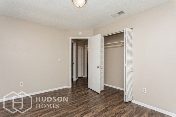 a living room with a door to a closet and a hallway