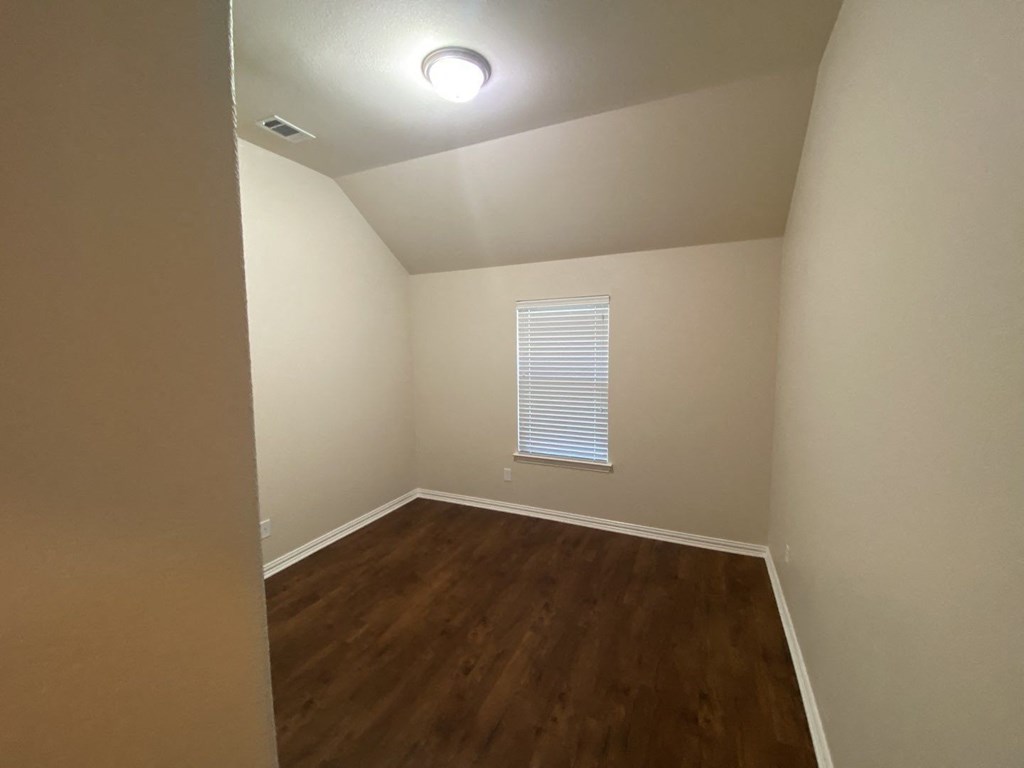 a empty room with hardwood floors and a window