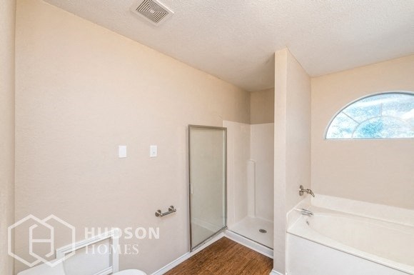 a bathroom with a tub and a shower and a window