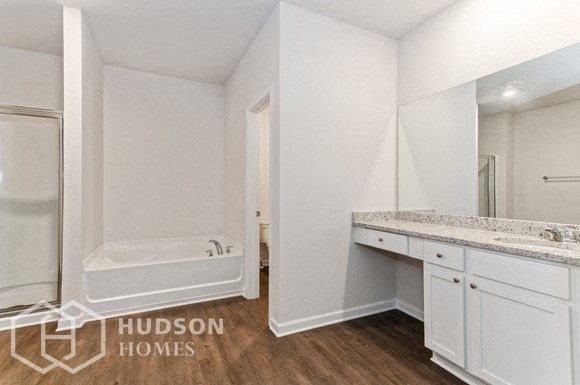 a white bathroom with a tub and a sink and a mirror