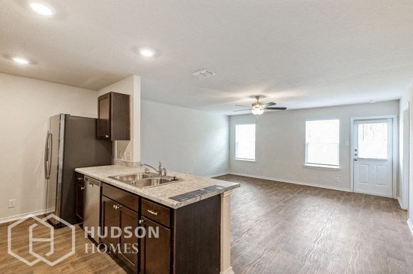 an empty kitchen with a sink and a refrigerator