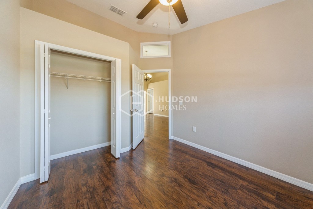 a bedroom with a closet and a ceiling fan and a door to a closet