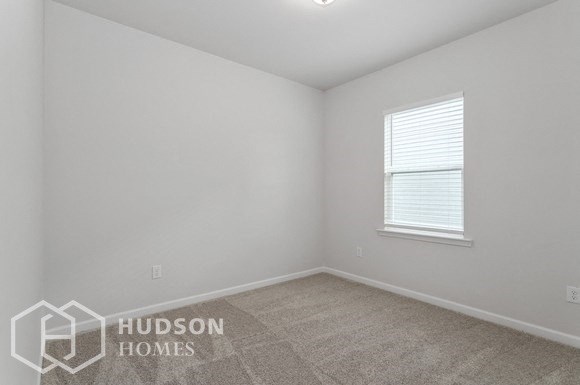 a white room with a window and a carpeted floor