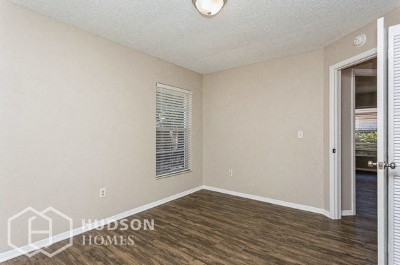 a living room with a door to a hallway and a window