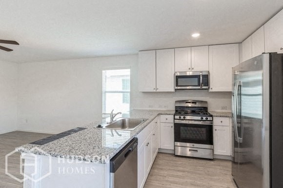 a kitchen with white cabinets and stainless steel appliances