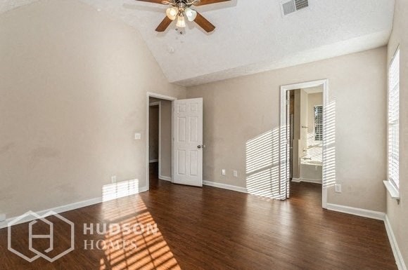 an empty living room with wood floors and a ceiling fan