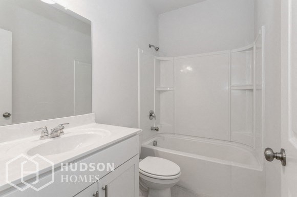 a white bathroom with a sink toilet and shower