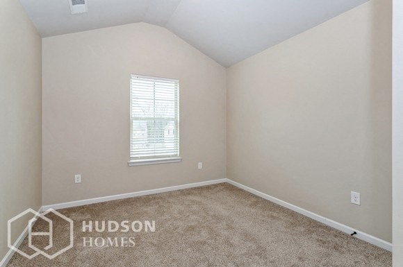 a bedroom with a carpeted floor and a window