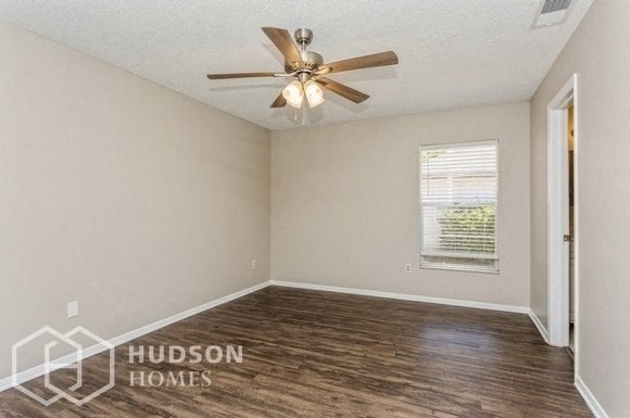 an empty room with a ceiling fan and a window
