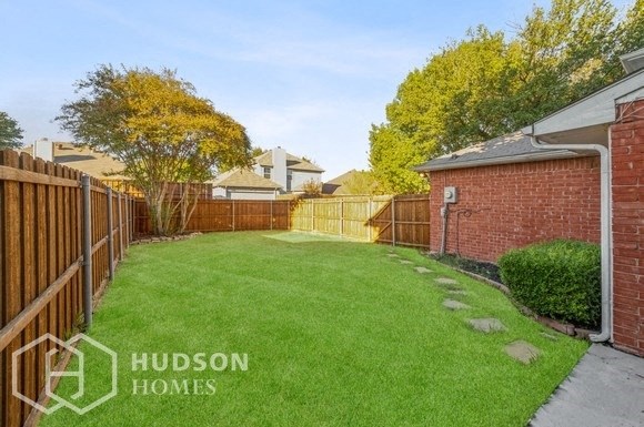 a backyard with green grass and a fence