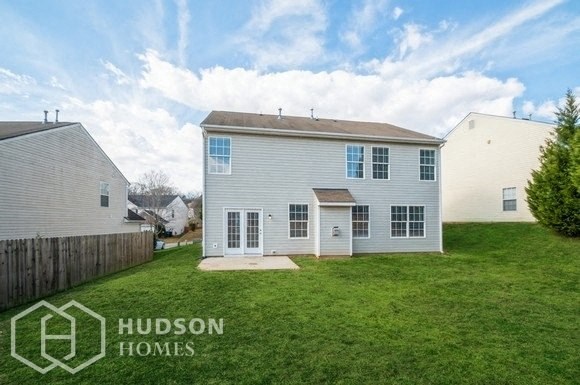 the back of a white house with a grassy yard