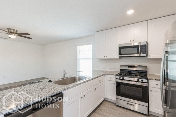 a kitchen with white cabinets and stainless steel appliances