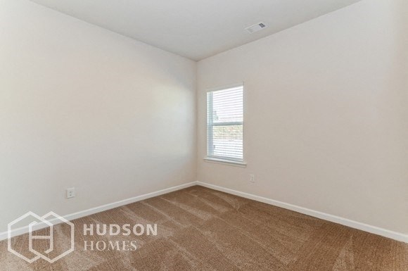 a white room with a window and a wooden floor