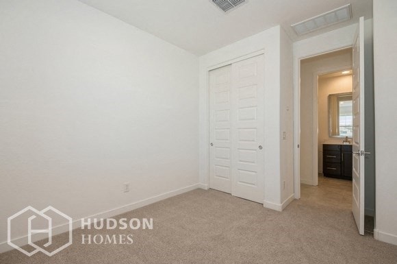 a bedroom with a closet and a door to a bathroom