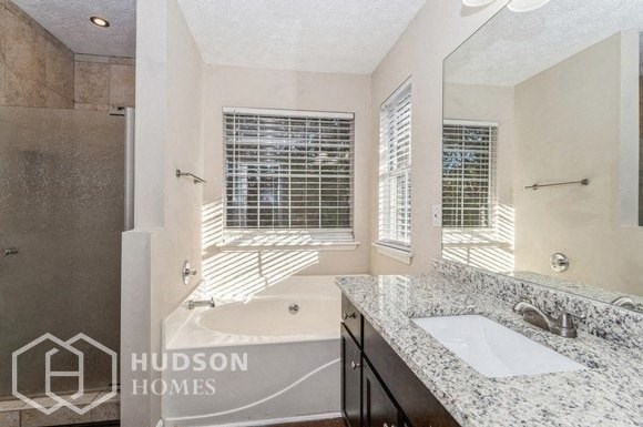 a bathroom with a tub and a sink and a mirror