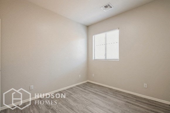 a white room with a window and wooden floors