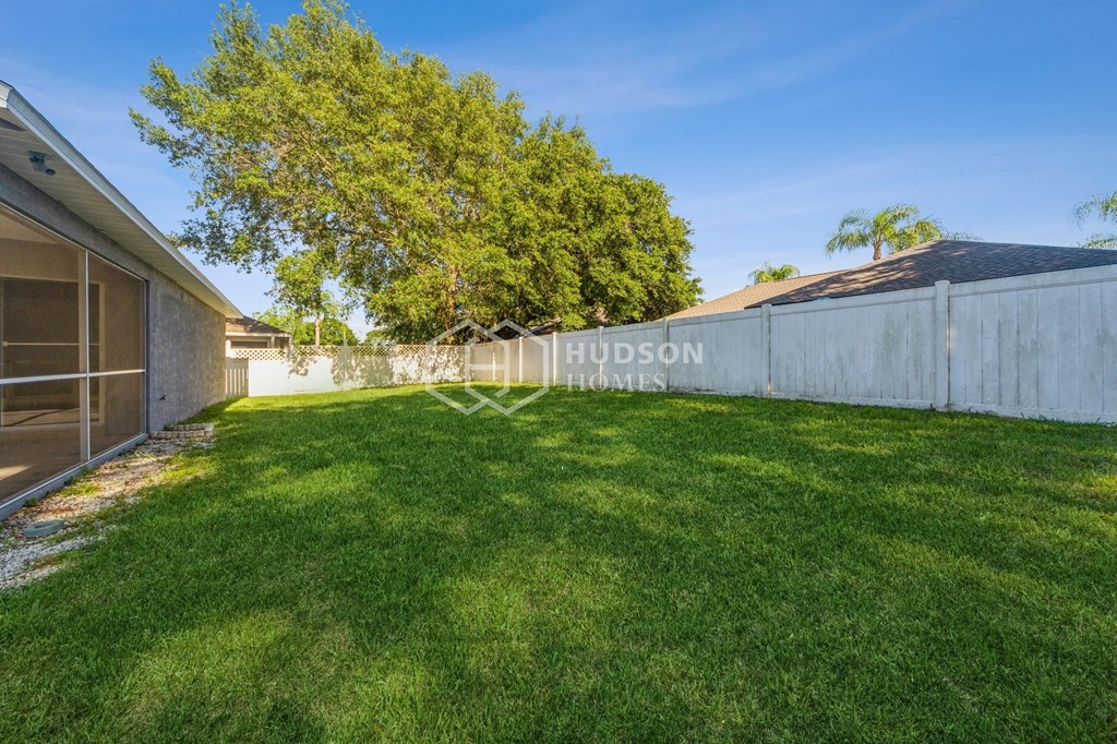a backyard with a fence and grass