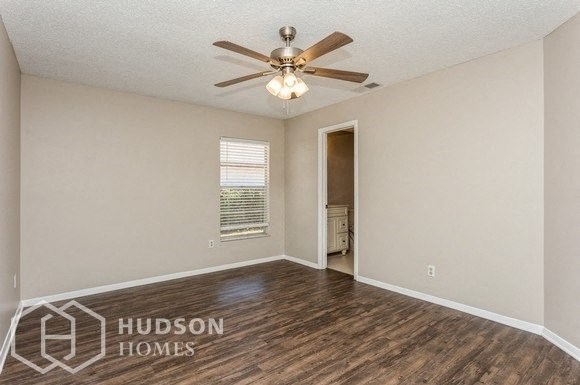 an empty living room with a ceiling fan and a window