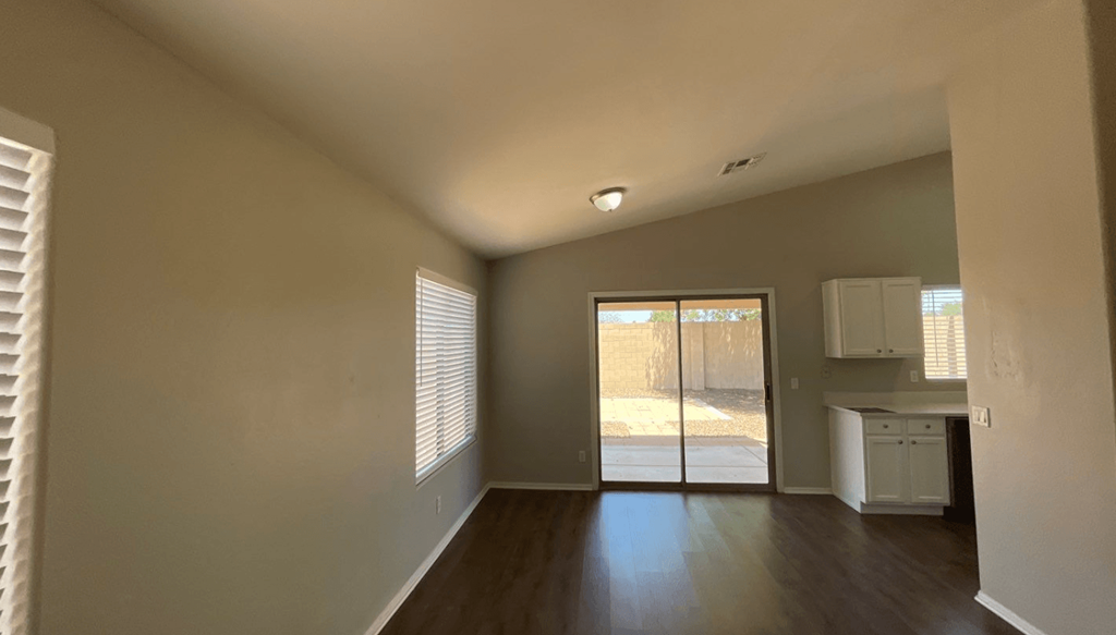 an empty living room with a door to a patio