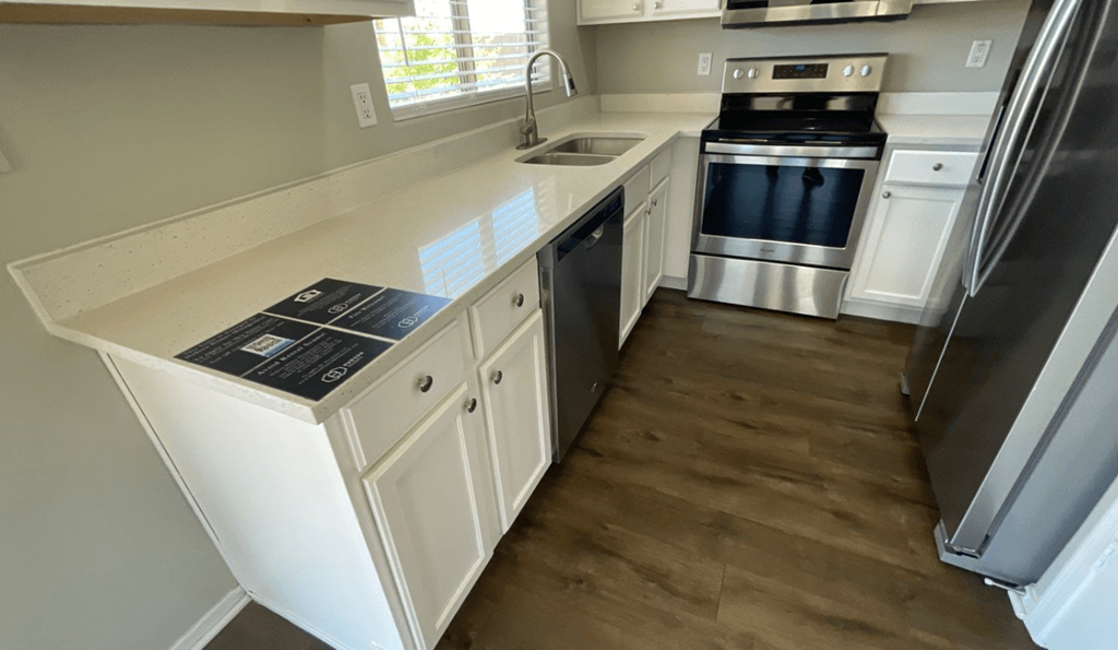 a kitchen with white cabinets and stainless steel appliances