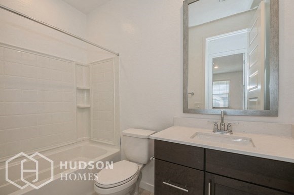 a white bathroom with a mirror and a toilet and a sink