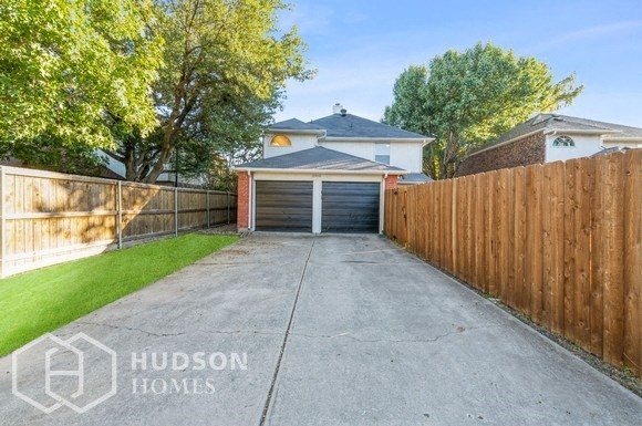 a driveway with a garage door in front of a house