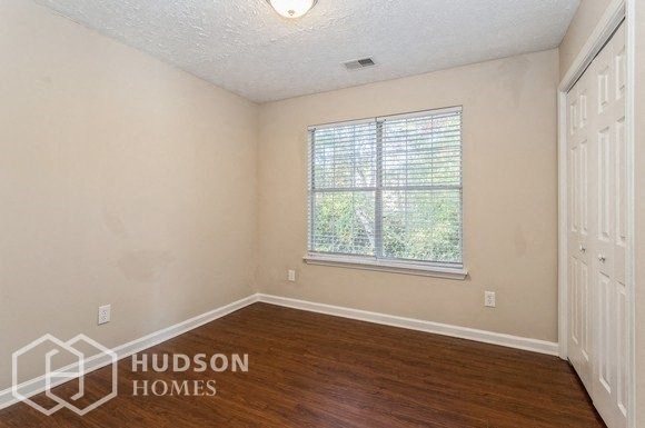 an empty room with a window and wooden floors