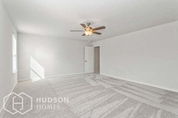an empty living room with a ceiling fan