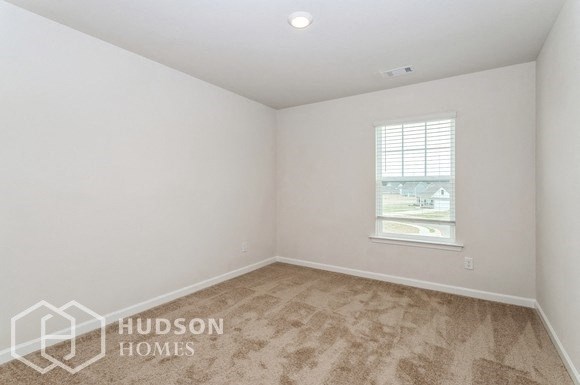 an empty room with a window and white walls and floors