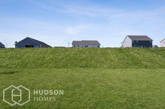 two houses on top of a grass covered hill