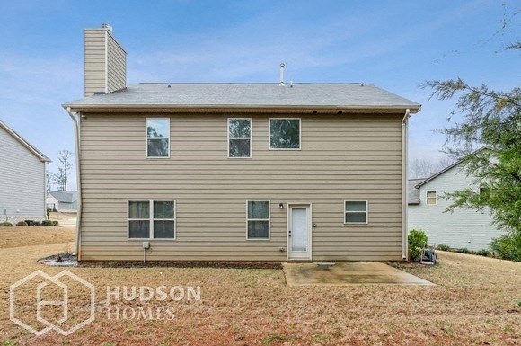 a small house with a white door and a yard