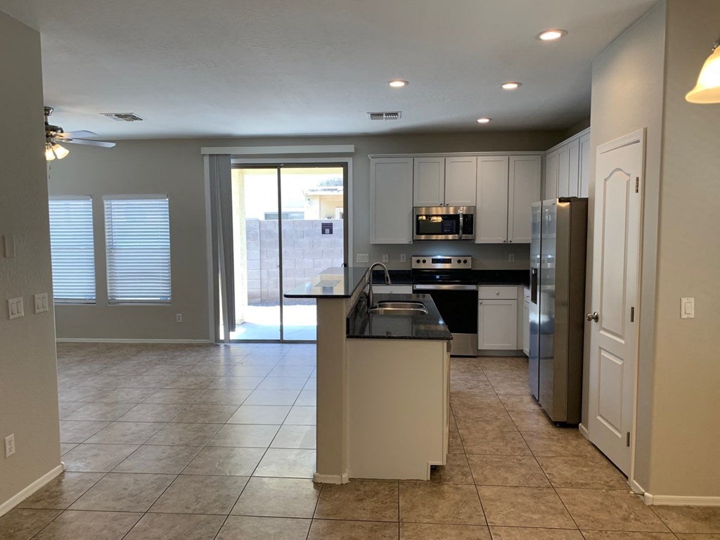 an empty kitchen with a refrigerator and a sink