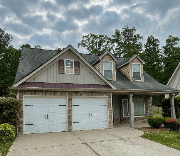 a house with two garage doors in front of it