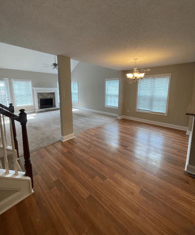 an empty living room with a hard wood floor and a fireplace