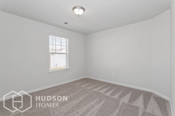 an empty room with a window and a carpet