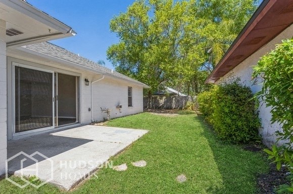a backyard with a patio and a white house