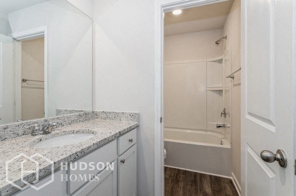 a bathroom with a sink and a shower and a mirror