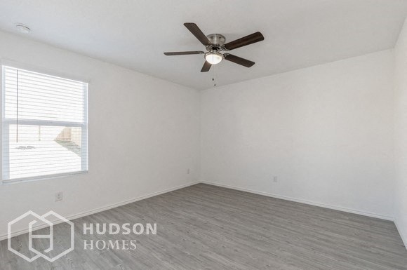 an empty room with a ceiling fan and a window