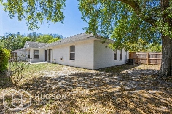 a small white house with a yard and a tree