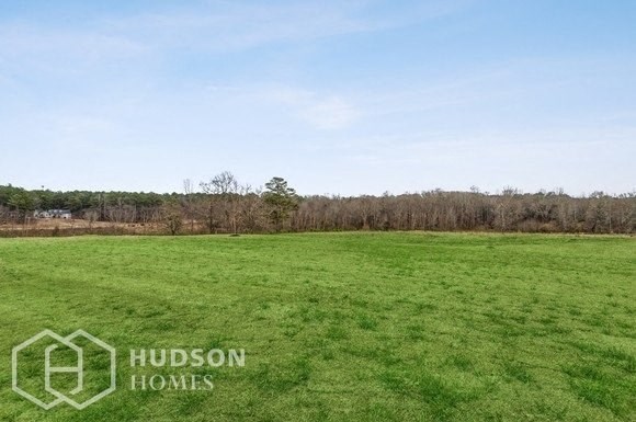a large field of grass with trees in the background