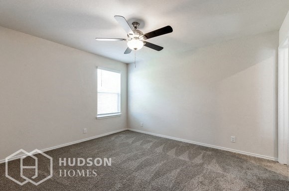 an empty room with a ceiling fan and a window