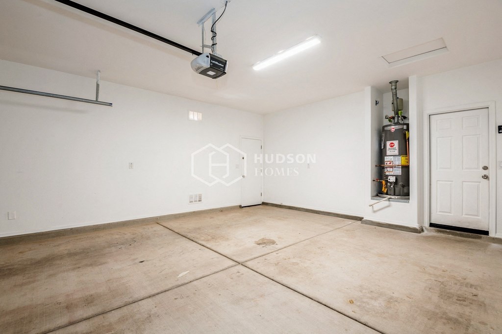 a large living room with a white door and a white wall with a gas heater