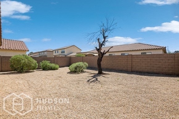 a backyard with a fence and a tree in the middle of it