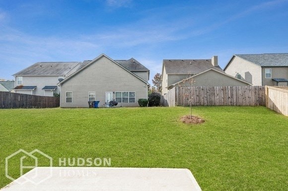 a backyard with a fence and two houses