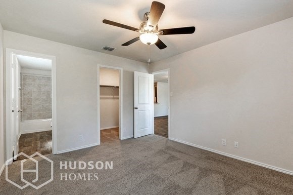 an empty living room with a ceiling fan and a closet