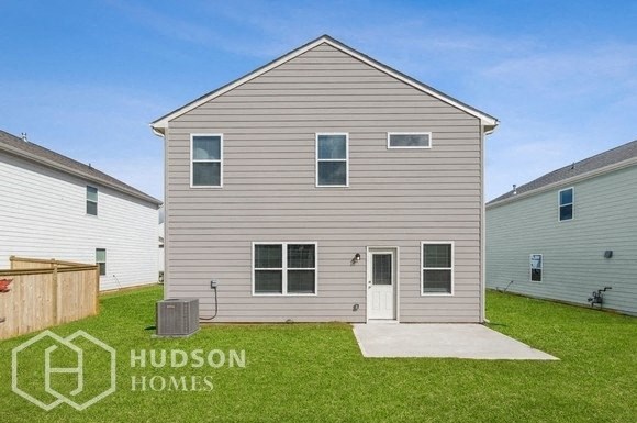 a small gray house with a yard in front of it